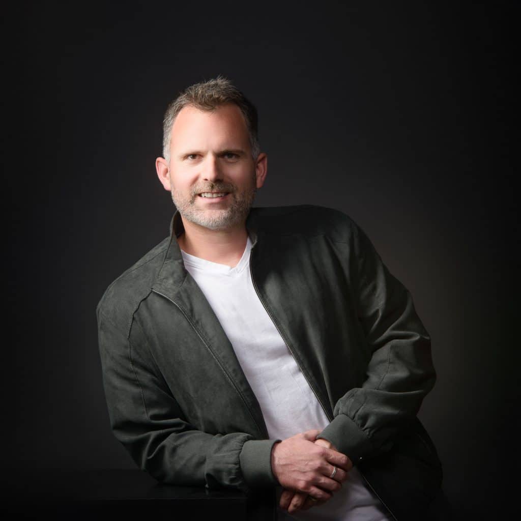 Homme souriant en veste verte et tee-shirt blanc, portrait corporate en studio à Annecy