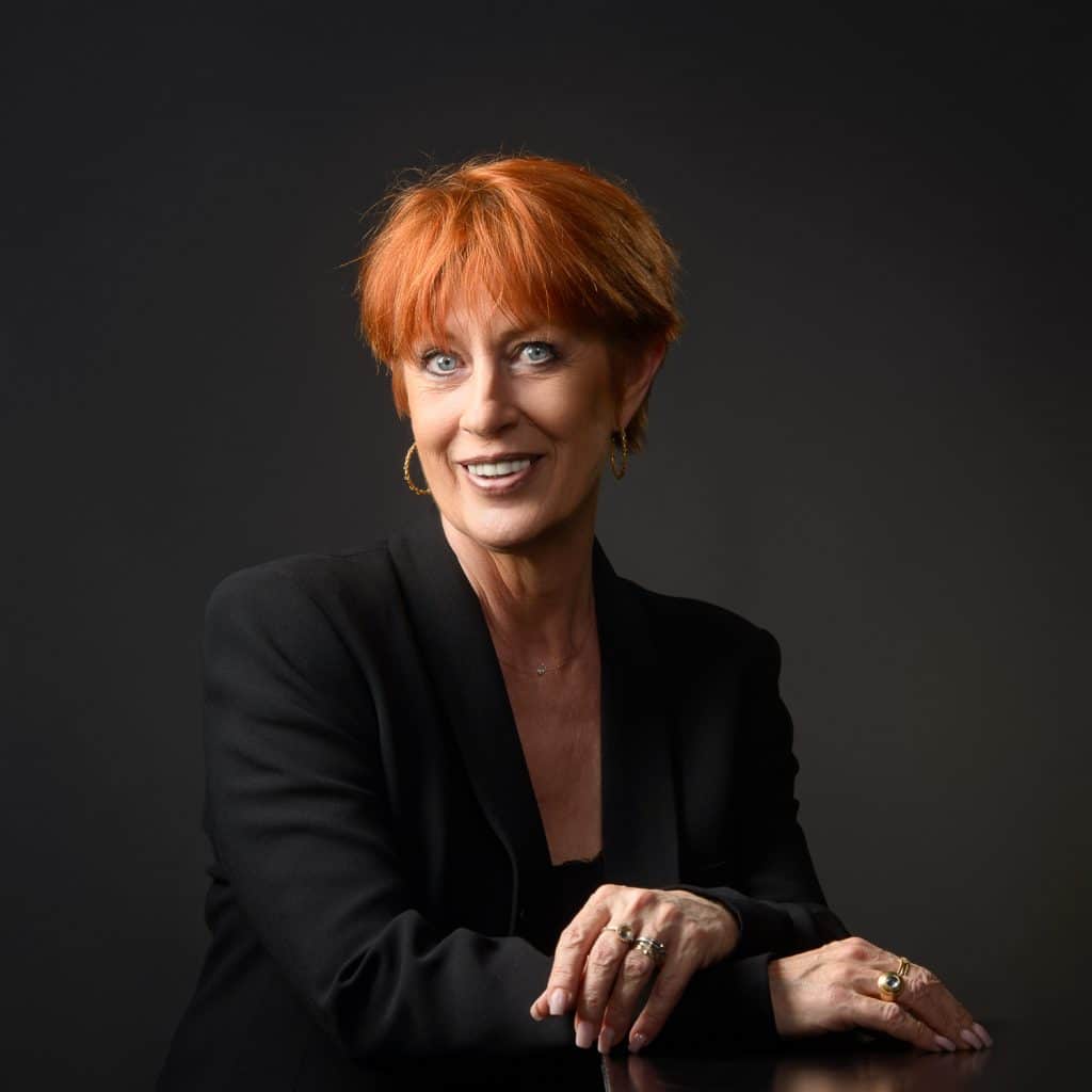 Femme aux cheveux roux courts en blazer noir, portrait corporate en studio à Annecy