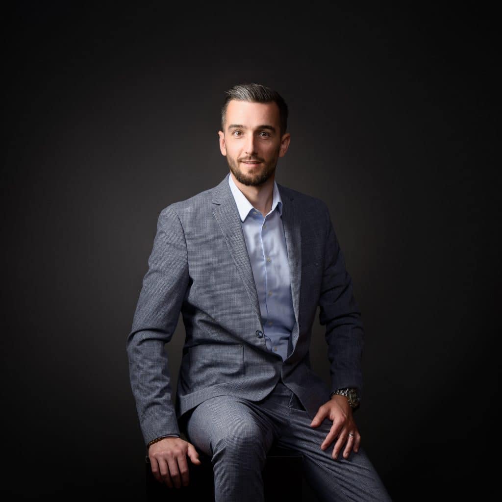 Homme en costume gris assis, portrait corporate pour site d'entreprise à Annecy
