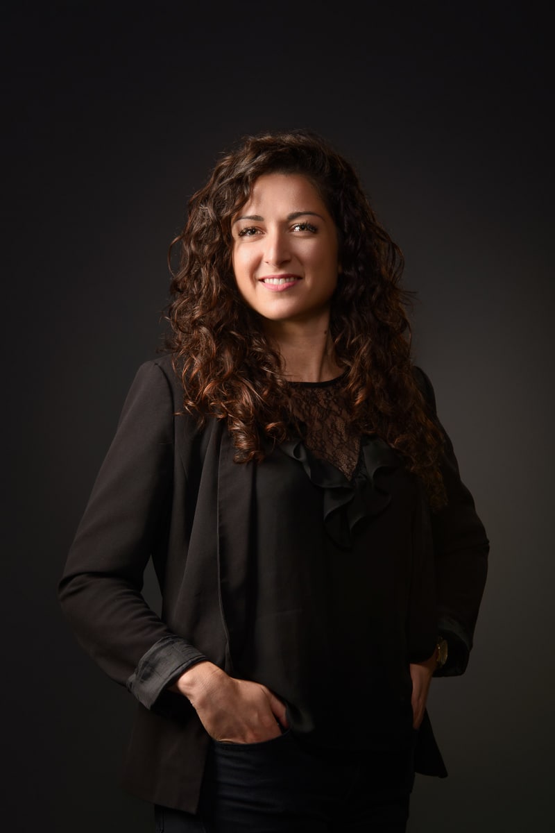 Femme aux cheveux bouclés en blazer noir, photo professionnelle pour CV à Annecy