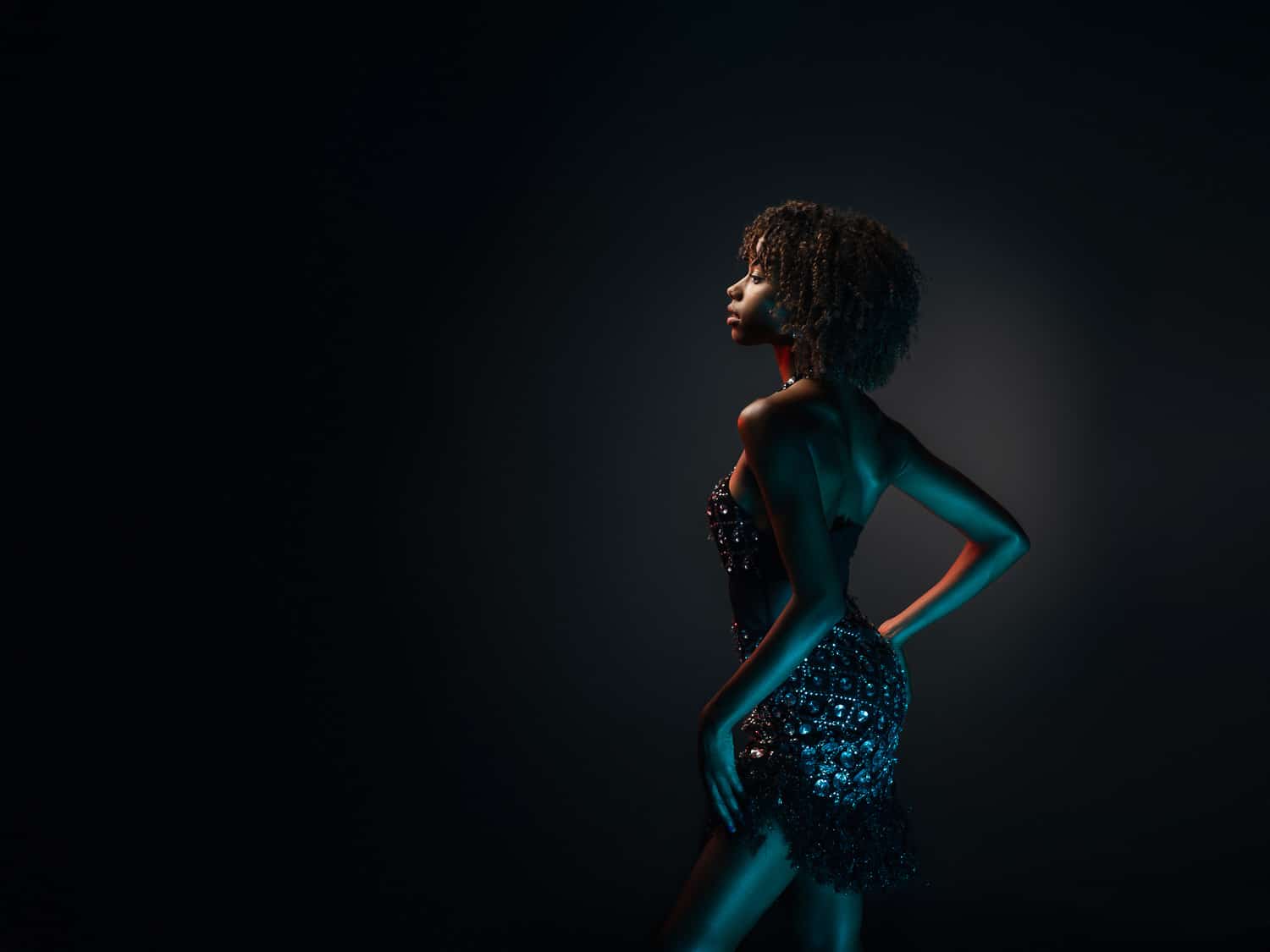 Modèle de profil en body à sequins, lumière bleue, séance book photo mode en studio à Annecy