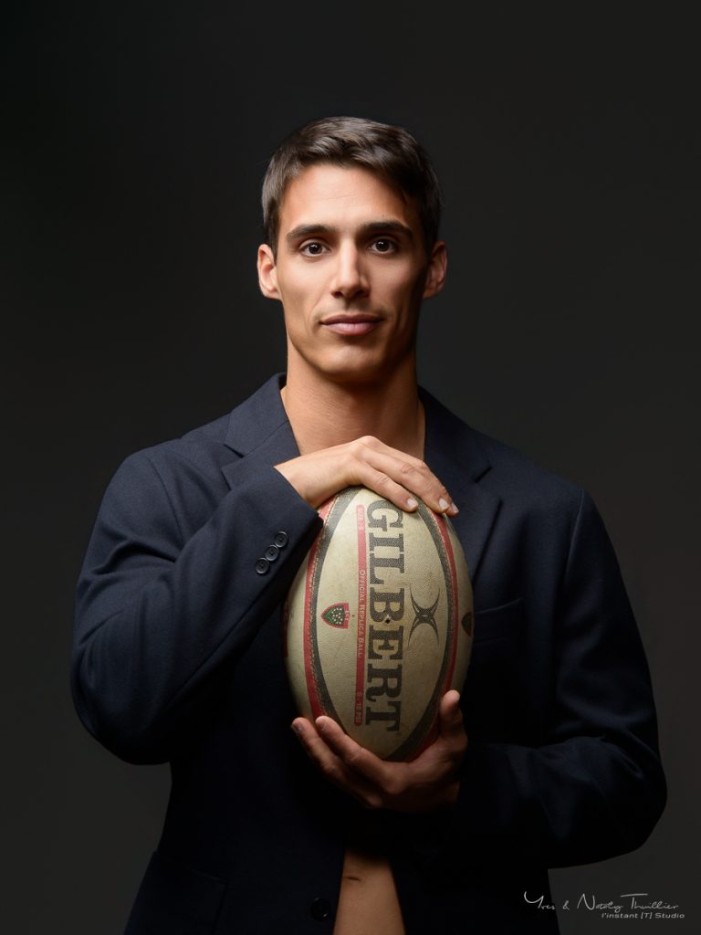 Portrait studio d’un ancien rugbyman à Annecy avec ballon de rugby pour un book photo homme
