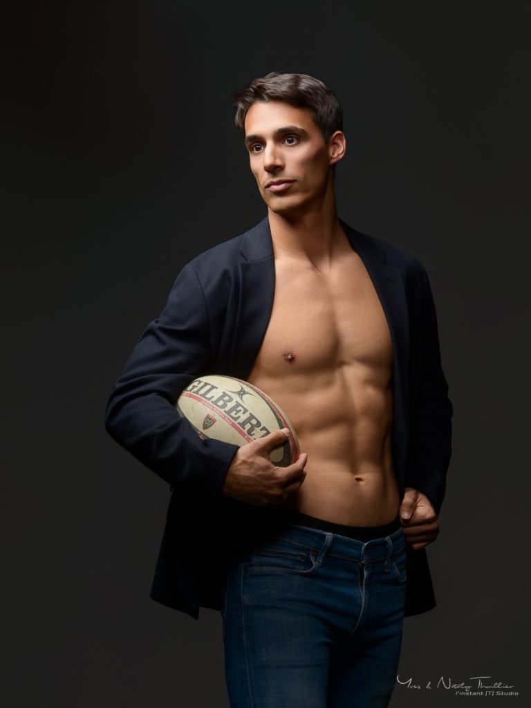 Portrait studio d’un ancien rugbyman à Annecy avec ballon de rugby pour un book photo homme
