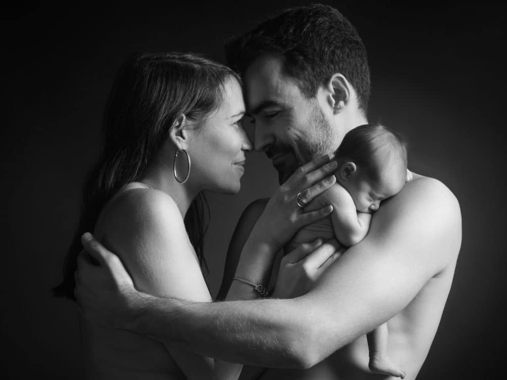 Couple tenant son nouveau-né, portrait en noir et blanc au studio d'Annecy