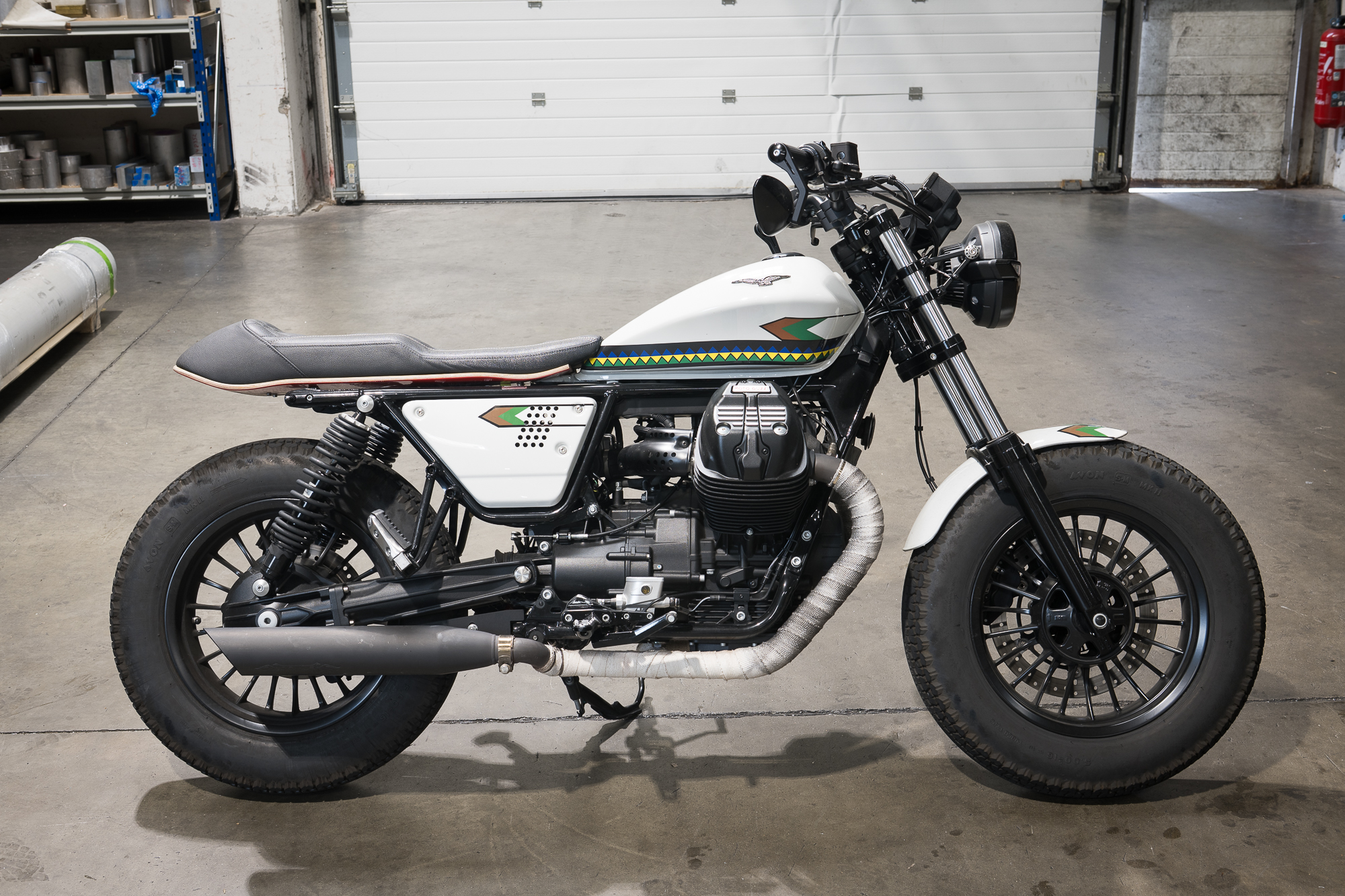 Moto café racer photographiée en lumière ambiante dans un garage