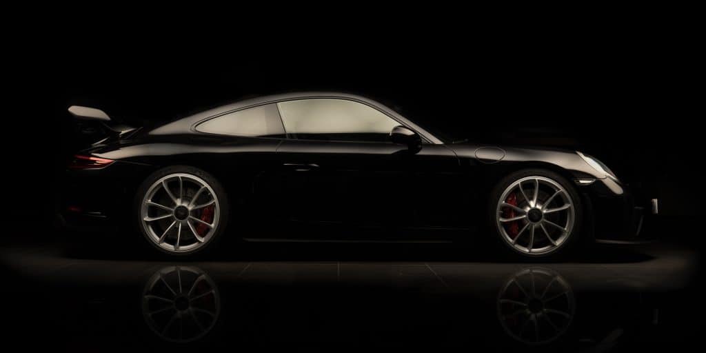 Porsche 911 noire de profil sur fond noir