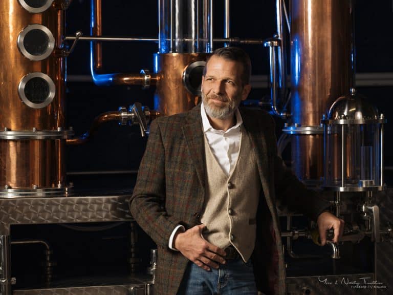 Portrait d’un distillateur devant ses alambics