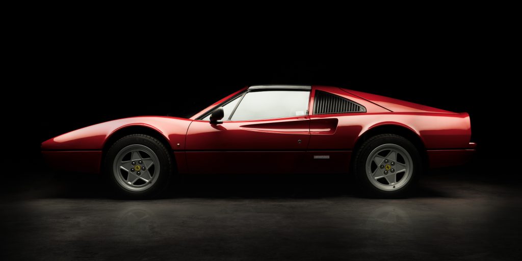 Ferrari 308 rouge de profil sur fond noir