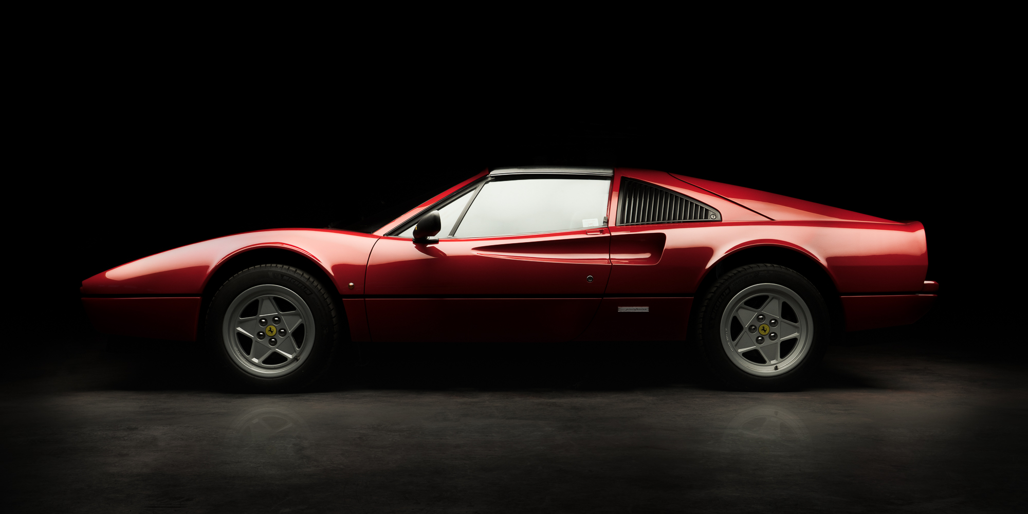 Ferrari 308 rouge de profil sur fond noir