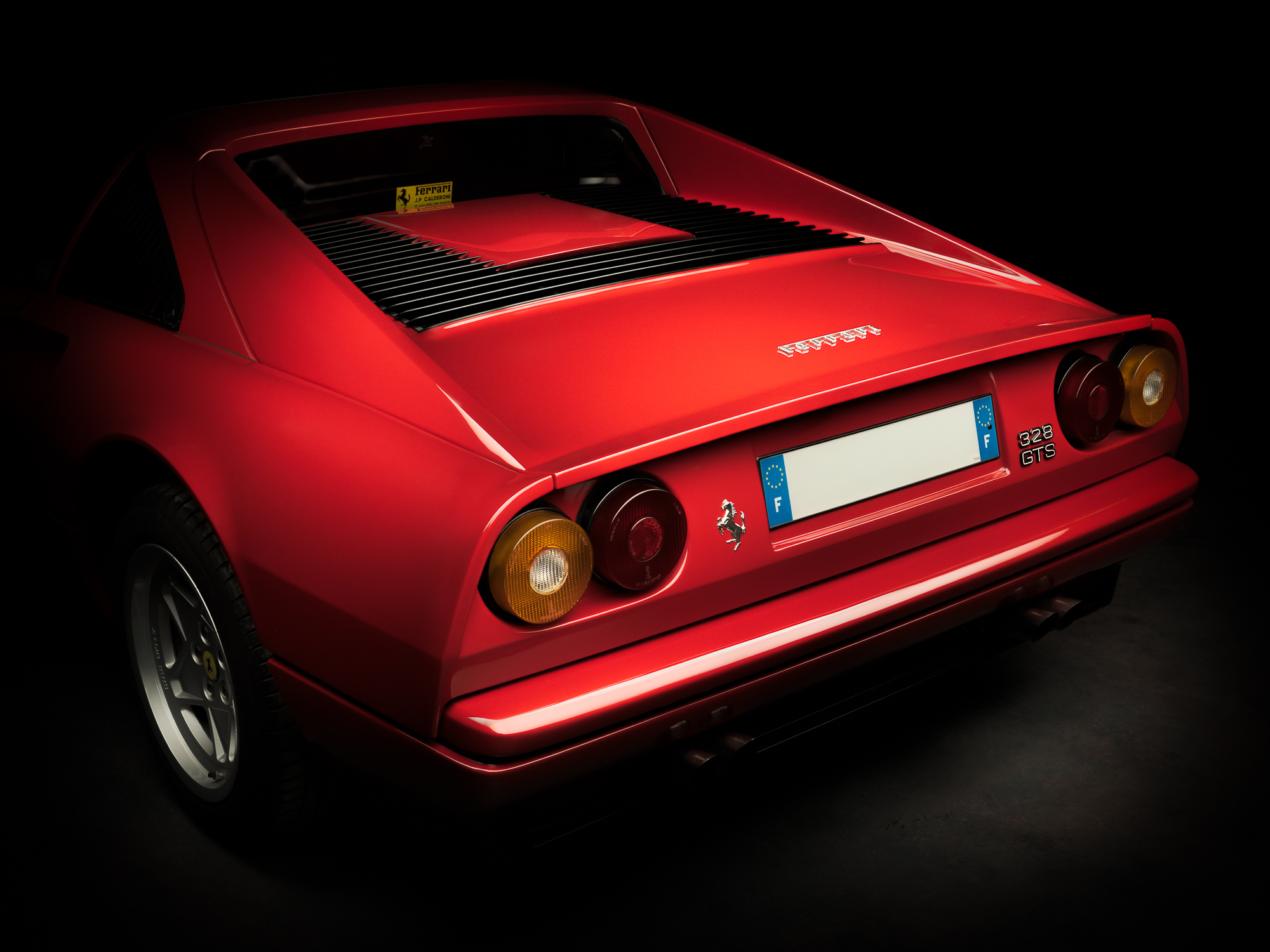 Ferrari 308 rouge vue arrière sur fond noir