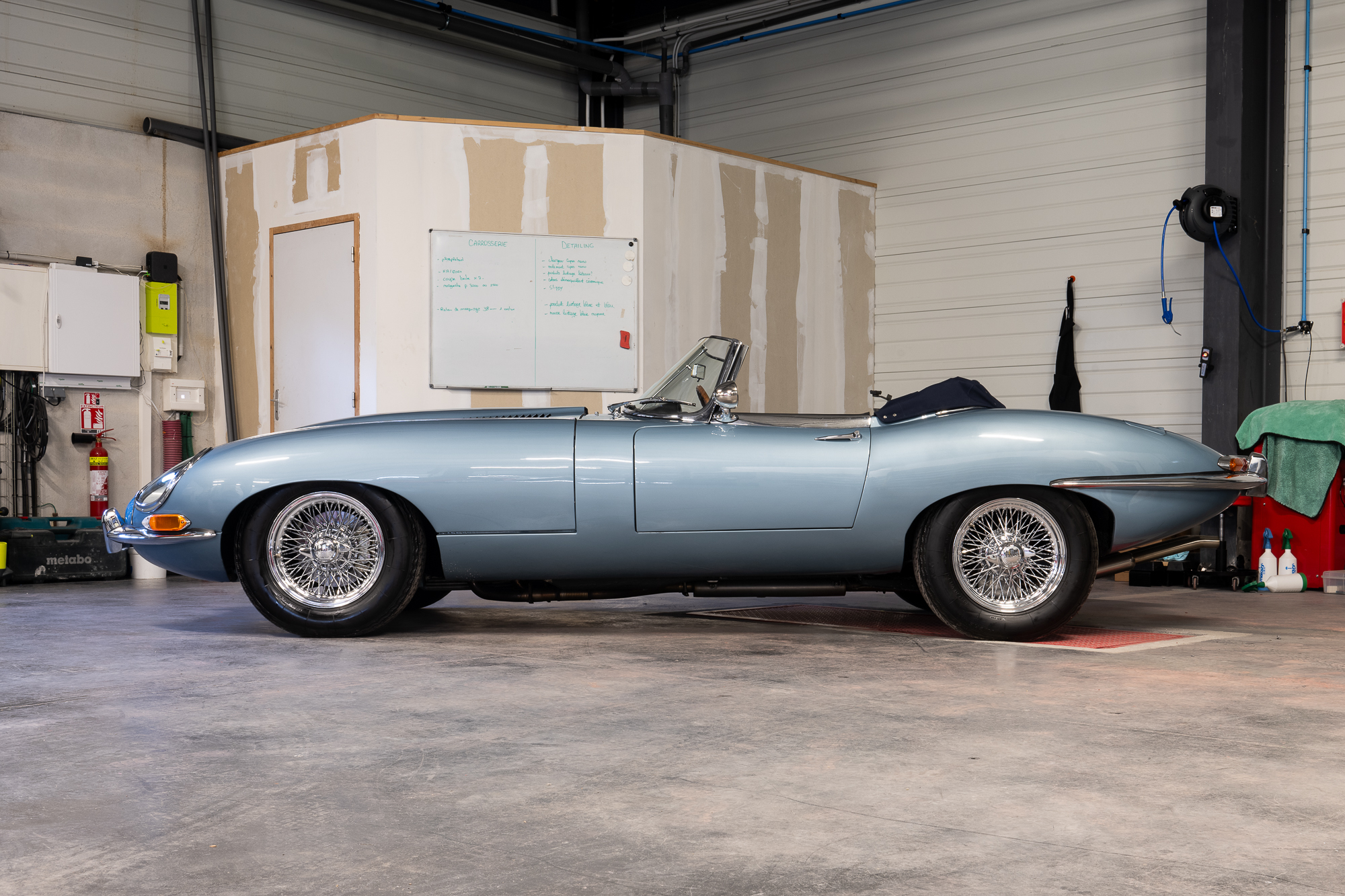Jaguar Type E photographiée en lumière ambiante dans un atelier, avant la mise en lumière