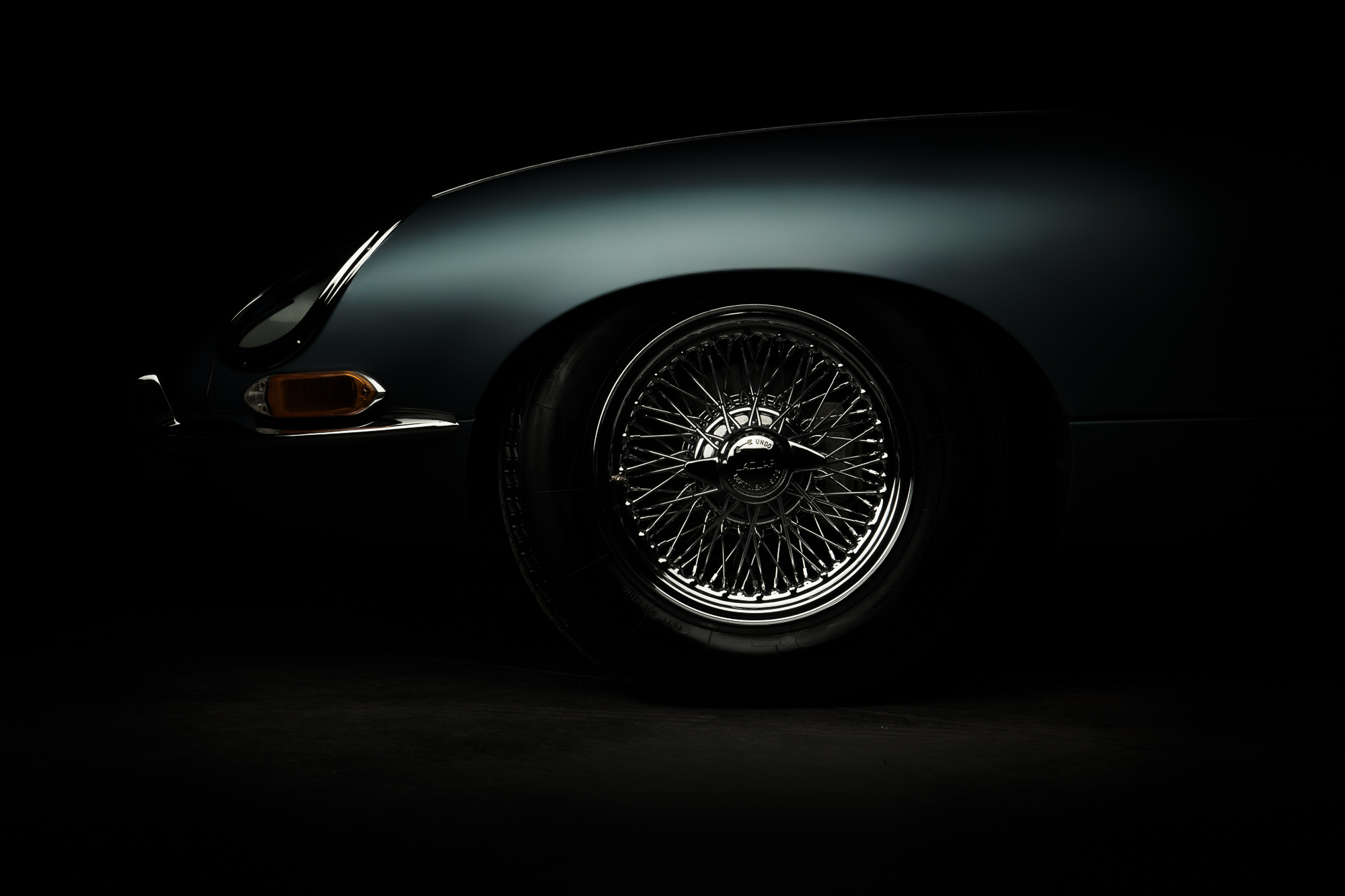 Roue à rayons d’une Jaguar Type E sur fond noir