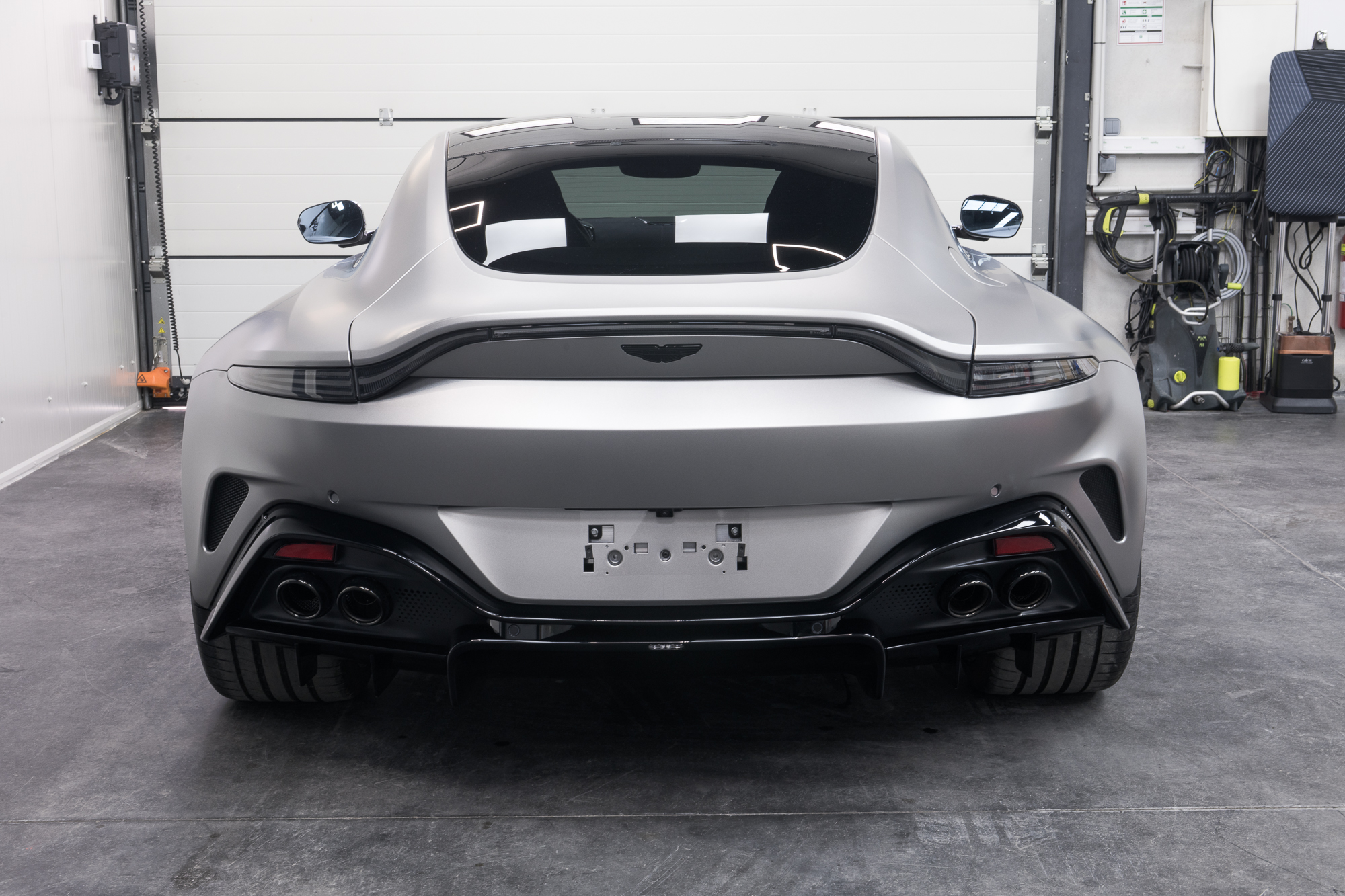 Aston Martin Vantage vue arrière en lumière ambiante dans un atelier