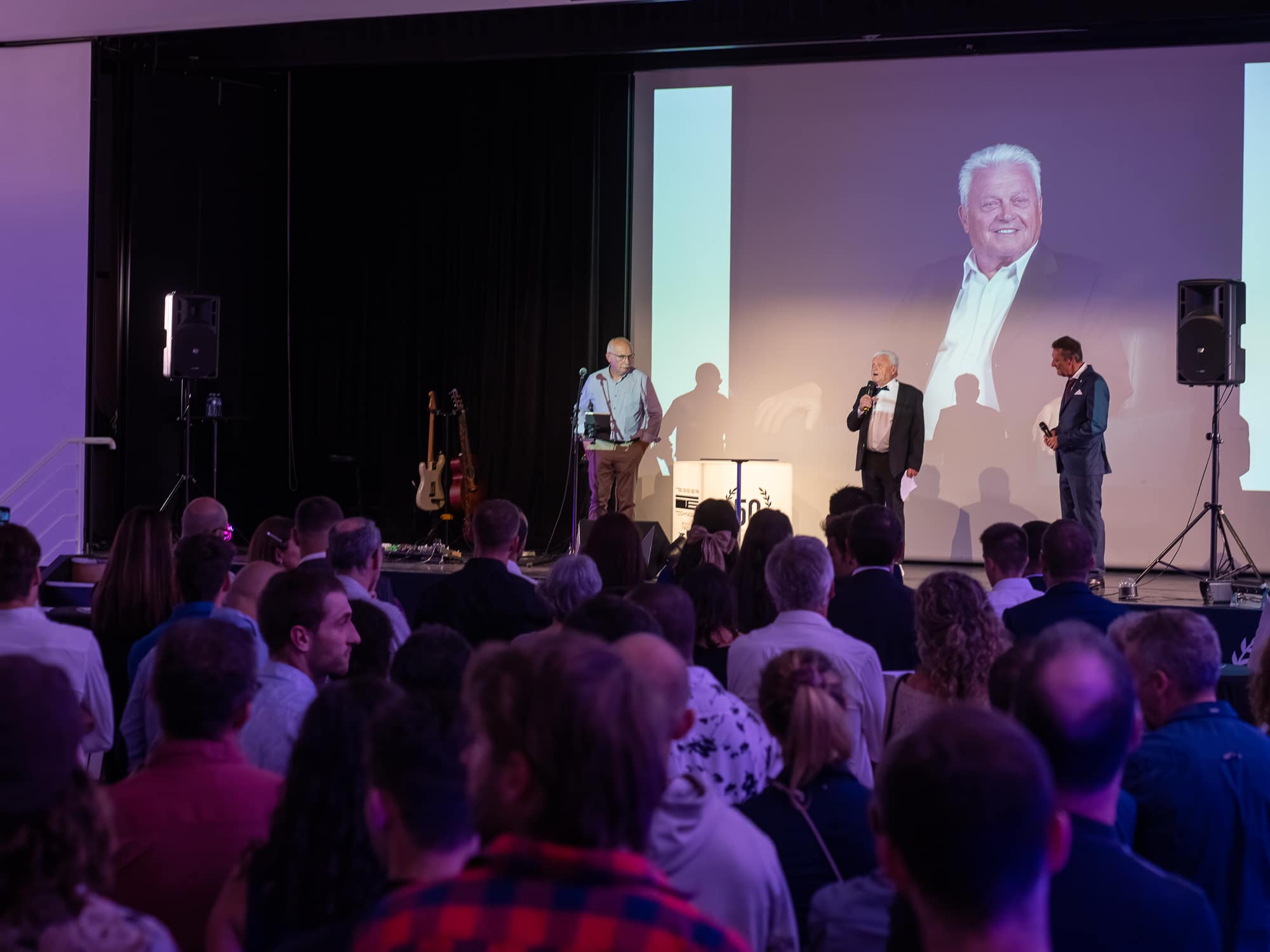 Salle comble face à la scène lors d’un séminaire d’entreprise
