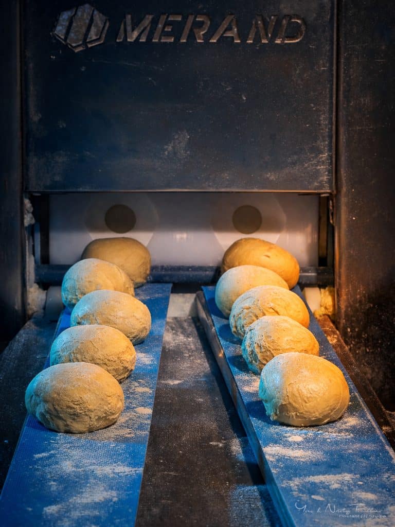 Pâtons sortant de la diviseuse sur le tapis, équipement d'un laboratoire de production boulangère
