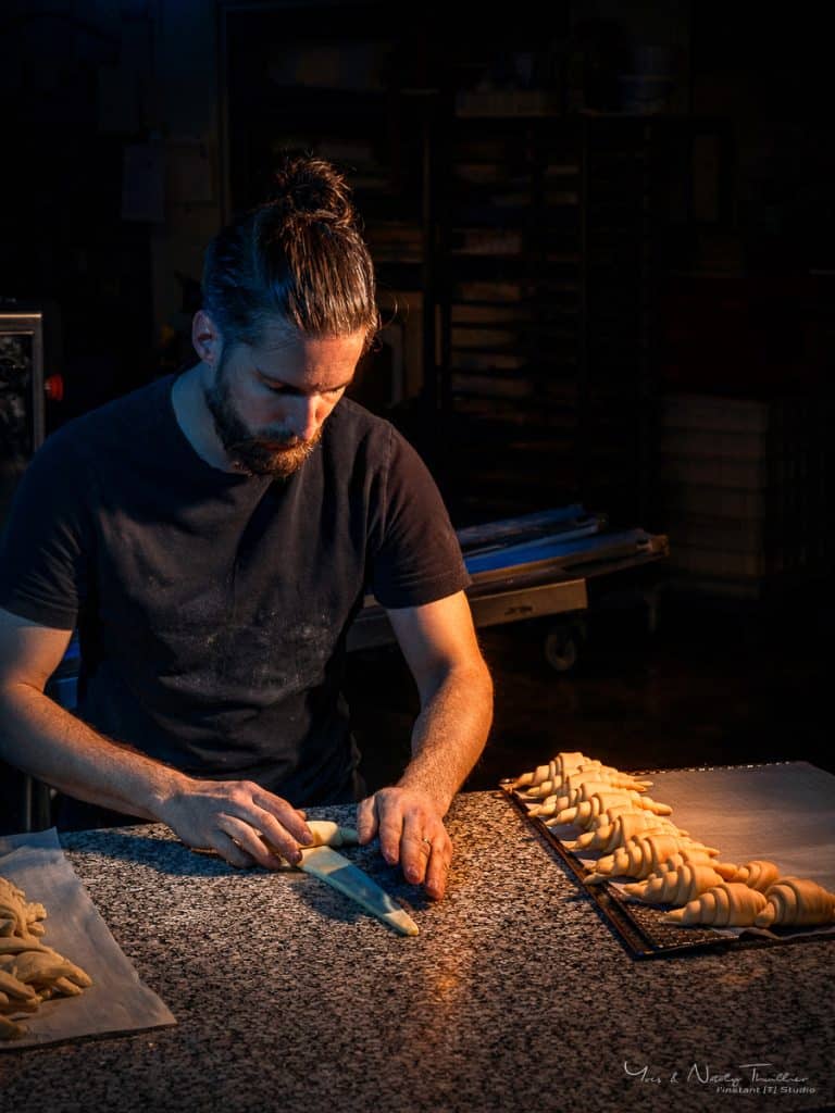 Boulanger façonnant des croissants à la main, portrait professionnel en environnement de production