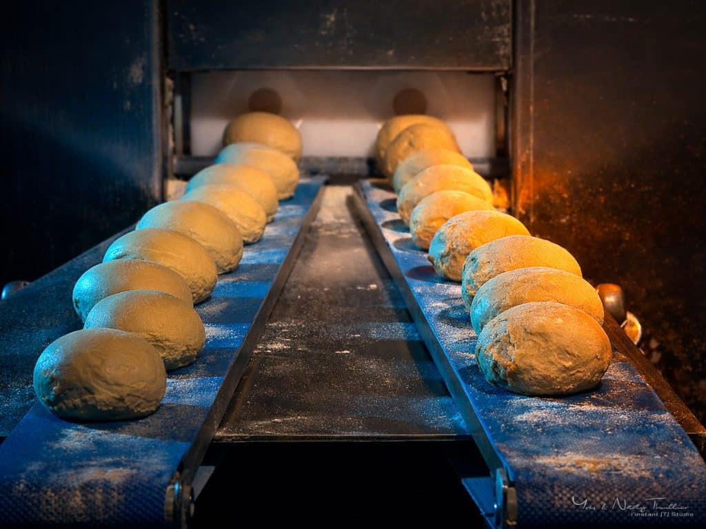 Pâtons alignés sur le tapis de la diviseuse, laboratoire de production boulangère près d'Annecy